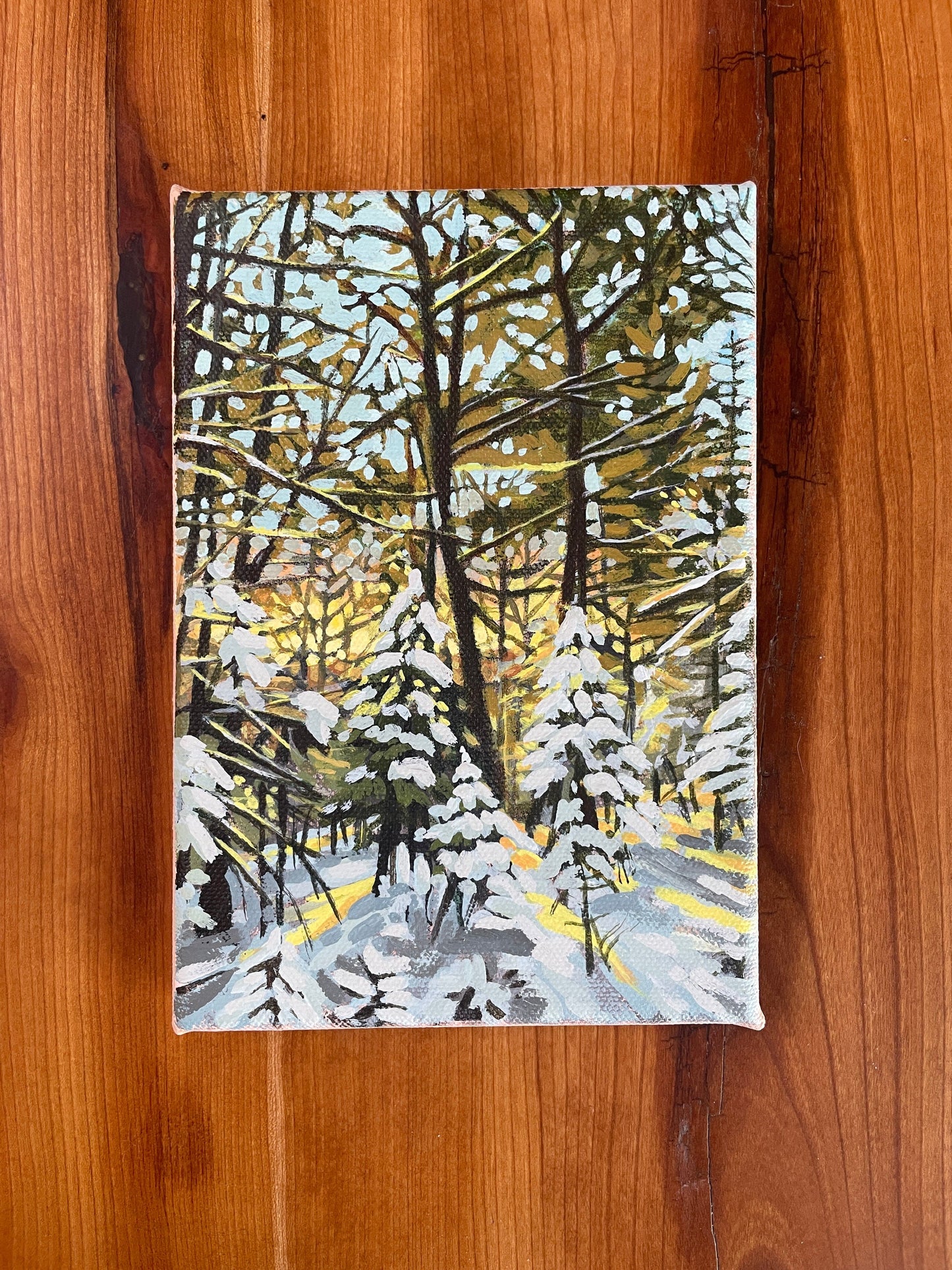 Golden Hour acrylic painting of gold sunbeams stretching through the snow covered forest. By Brandy Raymond